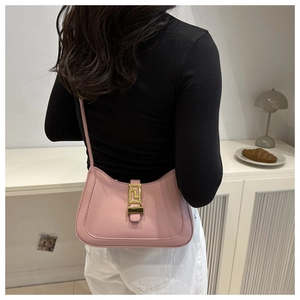 Detail of pink crescent underarm bag showing the sleek arc design and gold buckle