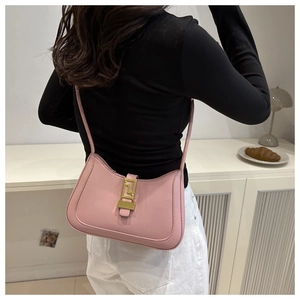 Pink crescent hobo bag with gold buckle and stitching details worn over the shoulder