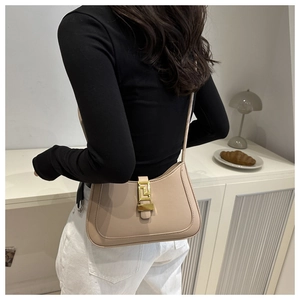 Detailed view of beige hobo shoulder bag with a stylish gold geometric metal buckle closure