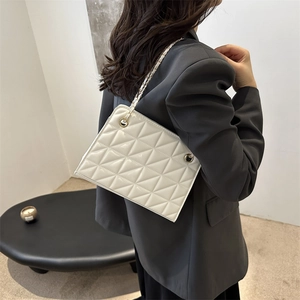 Minimalist white quilted tote bag with gold chain strap and elegant rhombus stitching