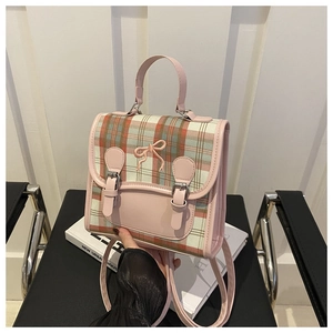 Detailed view of pink plaid mini backpack featuring bow embroidery and metal buckle straps