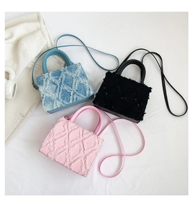Detailed macro view of tweed square handbags in blue, black, and pink with frayed edges