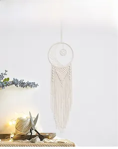 Close-up of handmade macrame moon dreamcatcher with woven star and cotton tassels