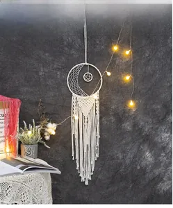 Detail of hand-woven moon dreamcatcher with star pendant and warm LED fairy lights