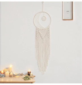 Macro detail of Bohemian hand-woven moon dream catcher with star pattern and long cotton tassels