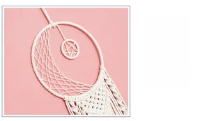 Detail of handmade woven moon dreamcatcher featuring white cotton rope and star charm