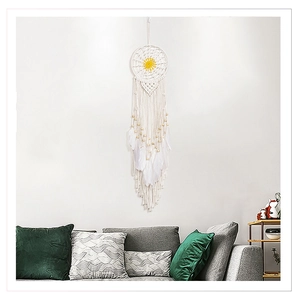 Détail d'un attrape-rêve fait main en coton blanc avec perles en bois et plumes
