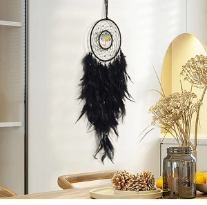 Detail of bohemian dream catcher with black feathers and tree of life gemstone center