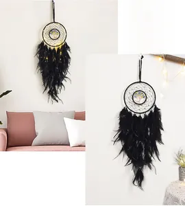 Detail of black dreamcatcher with tree of life design and warm LED feather fringe