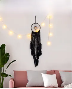 Detail of bohemian black dream catcher with tree of life metal piece and soft feathers