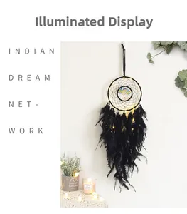 Close-up of black Tree of Life dreamcatcher with glowing warm LED string lights and feathers