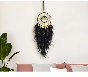 Detail of black Tree of Life dream catcher with feathers and LED lights on a white wall