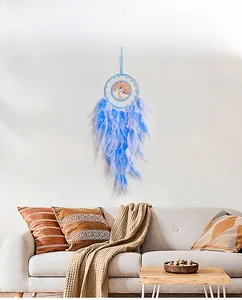 Detail of tree of life dreamcatcher with blue feathers hanging on a white wall