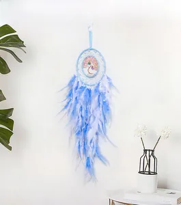 Detail of blue and white dreamcatcher featuring tree of life beads and hanging feathers