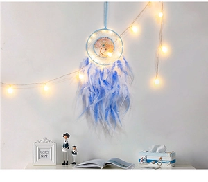 Macro detail of sky blue Tree of Life dream catcher with feathers and warm LED lights
