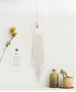 Detailed close-up of handmade white moon dreamcatcher with feathers and wood beads