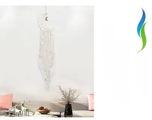 Detail of a large white moon dreamcatcher with handmade macrame weaving and feathers