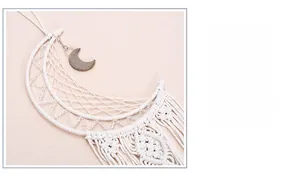 Detail of handmade crescent moon dreamcatcher with white cotton weave and tassels