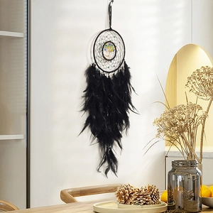 Black dreamcatcher with colorful tree of life and feathers hanging on a white wall