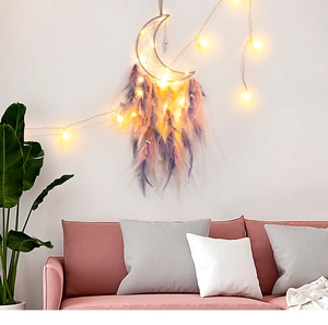 Detail eines grauen Mond-Traumfängers mit rosa Federn und warmen LED-Lichtern