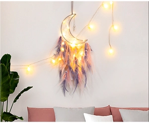 Detail eines mondförmigen Traumfängers mit rosa und lila Federn und LED-Beleuchtung