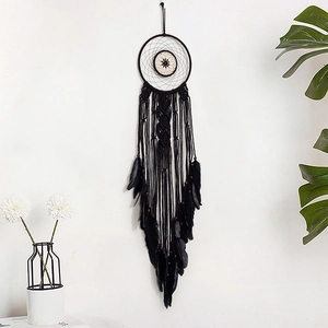 Handmade black dream catcher with beige woven center and feathers for wall hanging