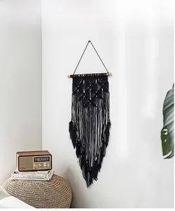 Detail of handmade bohemian wall hanging with black diamond woven mesh and feathers