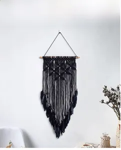Detailed view of handmade black bohemian macrame wall hanging with feathers and wooden beads