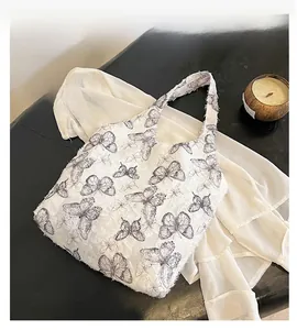 Detail of white tote bag with grey butterfly print and unique textured 3D feather fabric