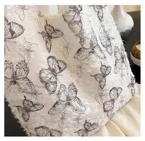 Detailed view of white tote bag featuring 3D butterfly embroidery and soft plush textures
