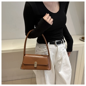 Detail of caramel leather shoulder bag with vintage silver twist lock and flap closure
