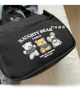 Detail of black canvas tote bag featuring three cartoon bears and Naughty Bear Three text