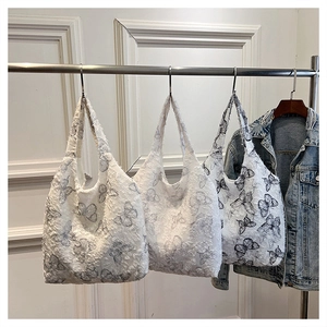Detail of butterfly pattern tote bag featuring fringe texture fabric and casual design