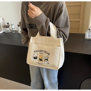 Detail of cute bear printed canvas tote bag with functional front pocket and handles
