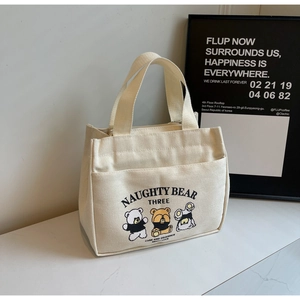 Detail of cute naughty bear prints and front pocket on off-white canvas tote lunch bag