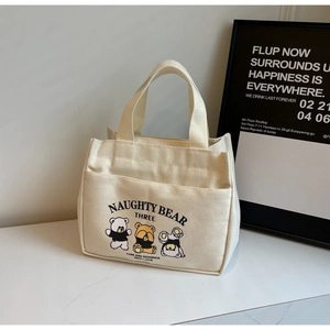 Detail of cute cartoon bear canvas lunch bag with zipper and front storage pocket