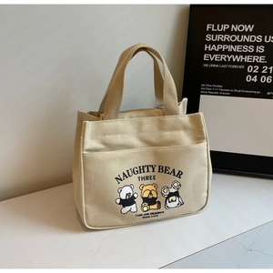 Detail shot of sturdy beige canvas tote with three cute cartoon bears and front pocket