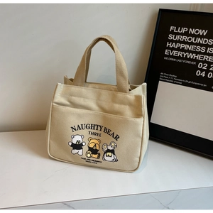 Detail of cute bear print on beige canvas tote bag with front pocket and sturdy handle