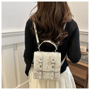 Detail of a mini square backpack with pink butterfly prints and adjustable PU leather straps
