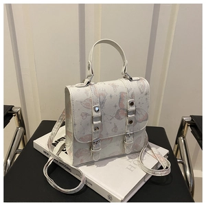Detail view of a white vintage crossbody bag with pink butterfly and star constellation prints