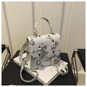 Detail of white structured crossbody bag with black butterfly print and metal buckle