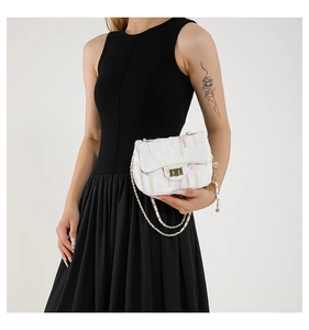 Detail of quilted mini chain bag with colorful macaron stripes and gold twist lock