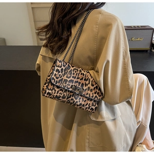 Detail shot of leopard print handbag with metal chain strap and pyramid stud lock