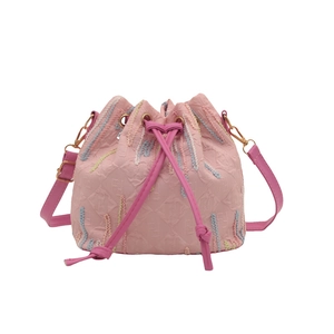 Pink drawstring bucket bag with embossed monogram pattern and gold-tone hardware detail