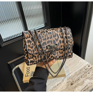 Detailed close-up of leopard print shoulder bag with metallic studded lock and chain strap
