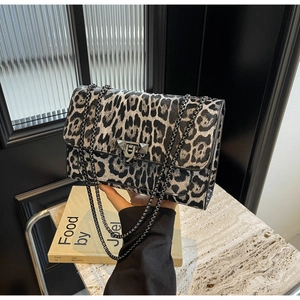 Detail of leopard print shoulder bag featuring rivet metal buckle and black chain strap