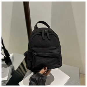 Close-up of lightweight black nylon backpack with durable zippers and top handle strap
