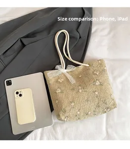 Gros plan du sac cabas beige tissé avec broderie florale et comparaison de taille