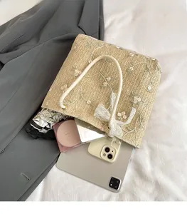 Vue de dessus du sac cabas en paille beige avec broderie florale et intérieur spacieux