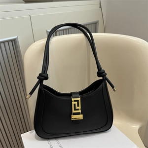 Vintage black hobo shoulder bag for women with gold geometric metal buckle on a chair